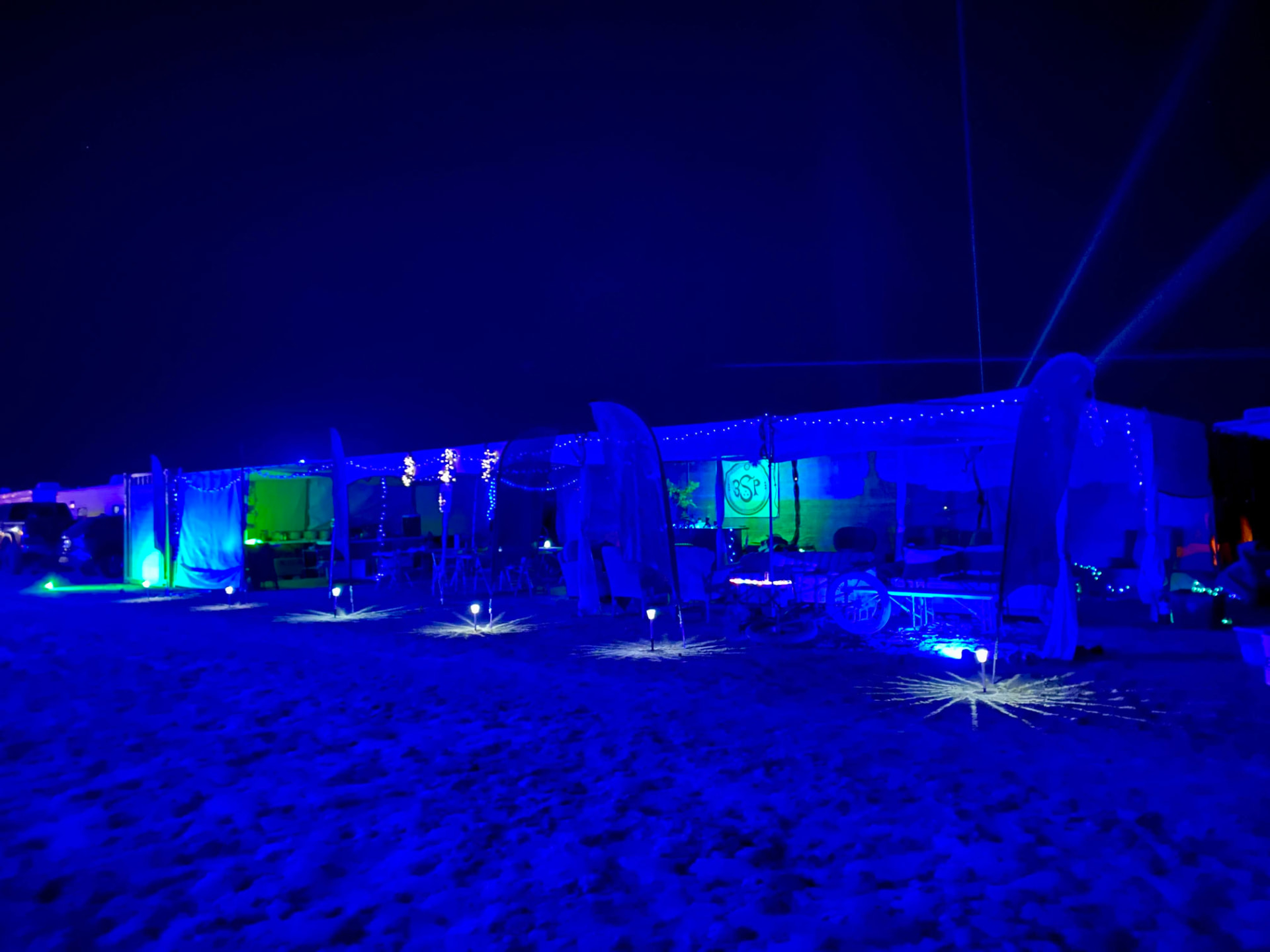 Vivarium camp structures lit blue and green after dark